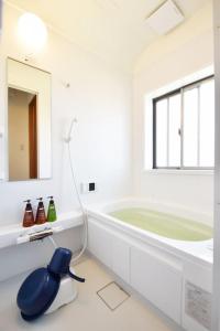 a white bathroom with a tub and a large mirror at Endless Summer in Shirako