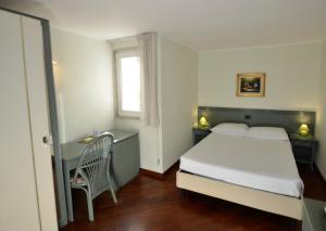 1 dormitorio con cama, escritorio y ventana en Zodiacus Residence, en Bari