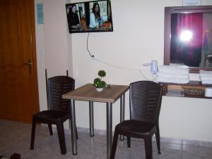 un tavolo e due sedie con tv a parete di Verginia Studios a Korinós
