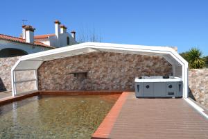 un patio al aire libre con barbacoa en una pared de ladrillo en Fazenda do Medronhal, en Montemor-o-Novo