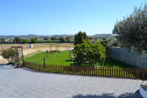un parque con valla y parque infantil en Fazenda do Medronhal en Montemor-o-Novo