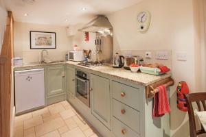 a kitchen with green cabinets and a counter top at Middle Cottage Southlands Farm in Gunnerton