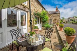 a patio with a table and chairs and a building at Middle Cottage Southlands Farm in Gunnerton
