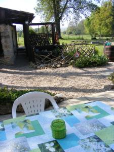 una mesa y una silla con un edredón en Gites Mirathon, en Baleyssagues