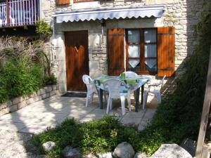 un patio con mesa y sillas frente a un edificio en Gites Mirathon, en Baleyssagues