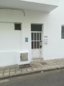 un edificio blanco con una puerta en el lateral de la calle en Hormiga's, en Corralejo