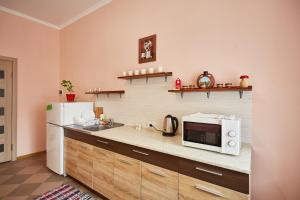 cocina con nevera blanca y microondas en Sweet Home, en Kamianets-Podilskyi