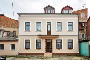 una gran casa blanca con muchas ventanas en Sweet Home, en Kamianets-Podilskyi