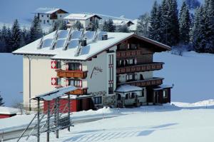 a building in the snow with snow at Aparthotel Garni Monte in Kartitsch