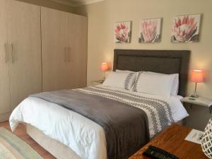 a bedroom with a large bed with two lamps at Forest Haven in Johannesburg