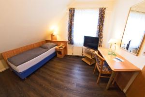 Cette petite chambre comprend un lit, un bureau et un ordinateur. dans l'établissement Hotel Restaurant Waldlust, à Hagen