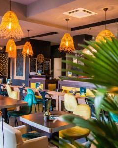 a restaurant with tables and chairs and lights at Le Safari Hotel Restaurant in Carpentras