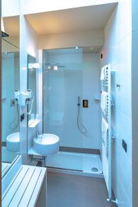 a bathroom with a glass shower and a sink at Hotel Moderno in Assisi
