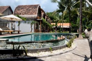 a swimming pool in front of a resort at Tentacle Bali in Nusa Penida