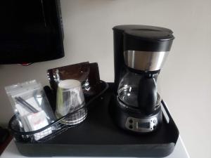 a black coffee maker sitting on a black tray at Moonlight Inn and Suites Sudbury in Sudbury