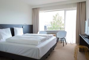 a hotel room with a bed and a large window at Hotel AM Fang in Bad Laasphe