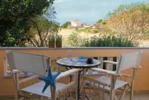 einen Tisch und zwei Stühle auf einem Balkon mit Aussicht in der Unterkunft Porto Limnia in Volissos