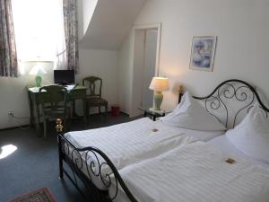 a bedroom with a bed and a desk with a laptop at Hotel Jägerhof in Mayen +72 photos