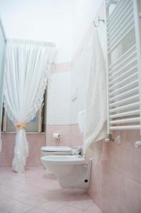 łazienka z toaletą i białą zasłoną w obiekcie B&B Villa Roma w mieście Piazza Armerina
