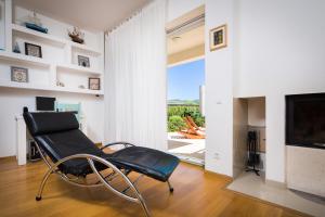 una sedia nera in un soggiorno con televisore di Luxury villa Wisdom near Split, private pool a Dugopolje (Dugopoglie)