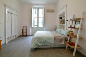 een witte slaapkamer met een bed en een raam bij Casa Cavour - Luxury Apartment in Sassari