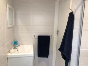 uma casa de banho com um lavatório e um chuveiro com uma toalha preta em Forest Haven em Joanesburgo