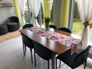 a dining room table with black chairs and a table cloth at Krakowska Apartamenty z Ogrodem i Parkingiem in Szczecin