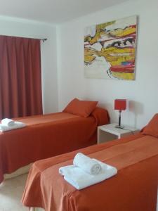 Dos camas en una habitación de hotel con toallas. en Punta Ramallo Posada en Ramallo