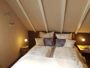 Schlafzimmer mit einem Bett mit weißer Bettwäsche und Kissen in der Unterkunft Ferienwohnung,Über Tage in Bochum