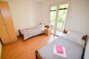 sypialnia z 2 łóżkami i dużym oknem w obiekcie Apartment Barona w Kotorze
