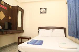 een slaapkamer met een bed, een spiegel en een televisie bij Star Residency in Chennai