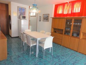 ビビオーネにあるBel Sole - Appartamentiのキッチン(テーブル、椅子、冷蔵庫付)
