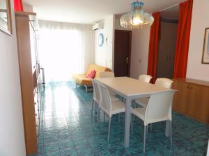 ein Esszimmer mit einem weißen Tisch und Stühlen in der Unterkunft Bel Sole - Appartamenti in Bibione