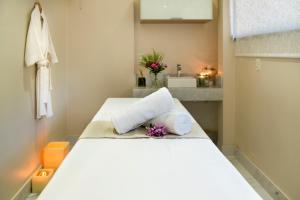 a bedroom with a bed with towels and a sink at Hotel Saint George in Puerto Iguazú