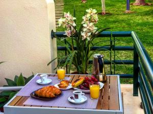 カニコにあるGarajau garden apatrtmentの食べ物とオレンジジュースのトレイ付きテーブル