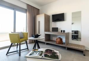 sala de estar con silla amarilla y TV en MIRAGE city APARTMENTS, en Rodas