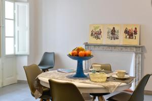 a dining room table with a bowl of fruit on it at Casa Cavour - Luxury Apartment in Sassari