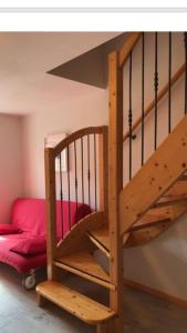 uma escada em espiral de madeira num quarto com uma cama em Appartamento Dalma Foresta em Lavarone