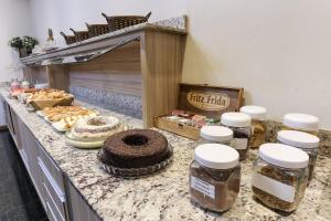 a counter with cakes and other food on it at Hotel Express Rodoviária in Porto Alegre