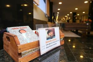 a box of books on a table with a sign at Hotel Express Rodoviária in Porto Alegre