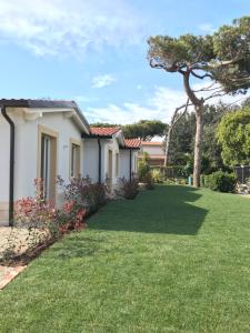 a house with a yard with green grass at Il Miraggio in Fregene
