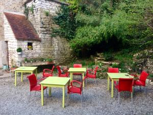 eine Gruppe von Tischen und Stühlen vor einem Gebäude in der Unterkunft La Ferme de la Fosse Dionne in Tonnerre