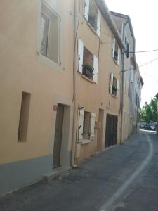 una calle vacía al lado de un edificio de apartamentos en Au 10, en LʼIsle-sur-la-Sorgue