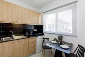 Una cocina con una mesa y sillas y un fregadero. en MIRAGE city APARTMENTS, en Rodas