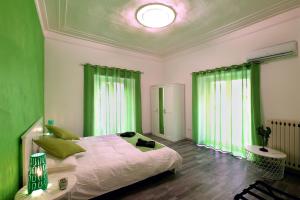 um quarto com cortinas verdes e uma cama grande em Tembo House - Pantano 1 em Catânia