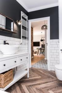 a bathroom with a white sink and a mirror at Apartament przy Zachodnim in Olsztyn