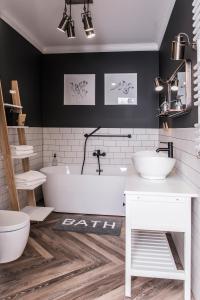 a bathroom with two sinks and a bath tub at Apartament przy Zachodnim in Olsztyn