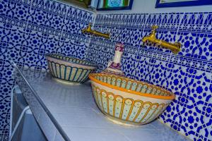 duas tigelas num balcão numa cozinha azulada e branca em Riad Dari em Tetouan