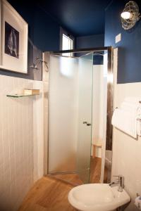 y baño con ducha de cristal y aseo. en Hotel Montecarlo - Vista Mare con Area Fitness, en Riccione