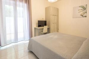 a bedroom with a bed and a desk and a television at La Casa Sul Corso in Santa Maria di Castellabate